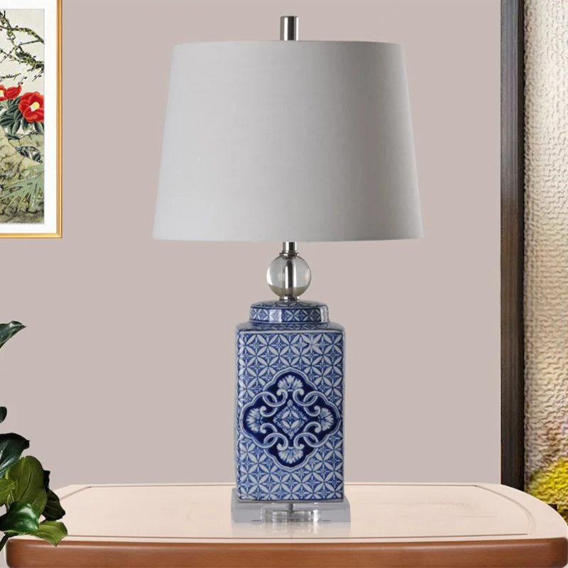 Elegant blue and white porcelain table lamp with floral design and ivory shade.