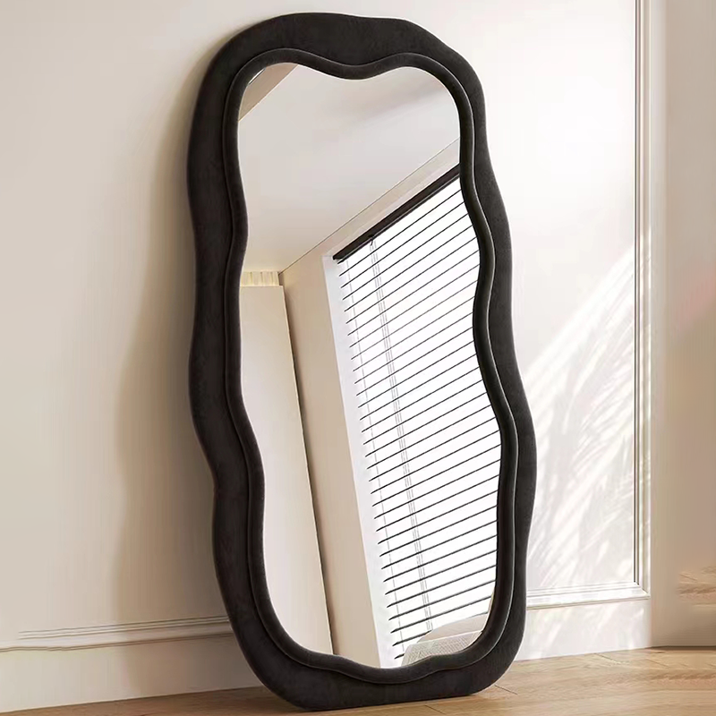 Elegant wavy black full-length mirror showcasing its unique wave design in a bright living room.
