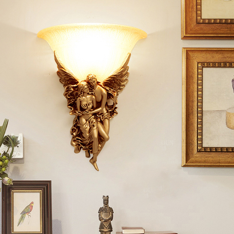 Elegant gold resin angel wall sconce illuminating a stylish living room.