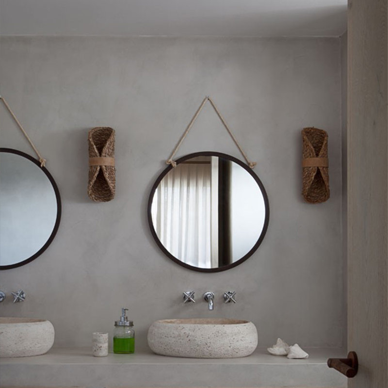 The rattan wall lamp illuminating a cozy bedroom corner, enhancing the boho decor theme.