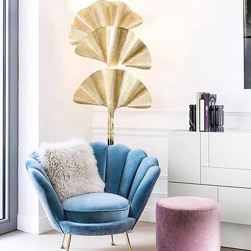 Elegant ginkgo leaf floor lamp in gold showcasing its intricate design in a cozy living room.