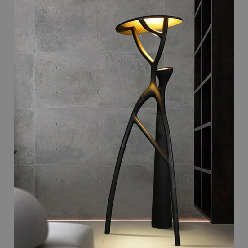 The black floor lamp illuminating a bedroom, creating a warm and inviting atmosphere.