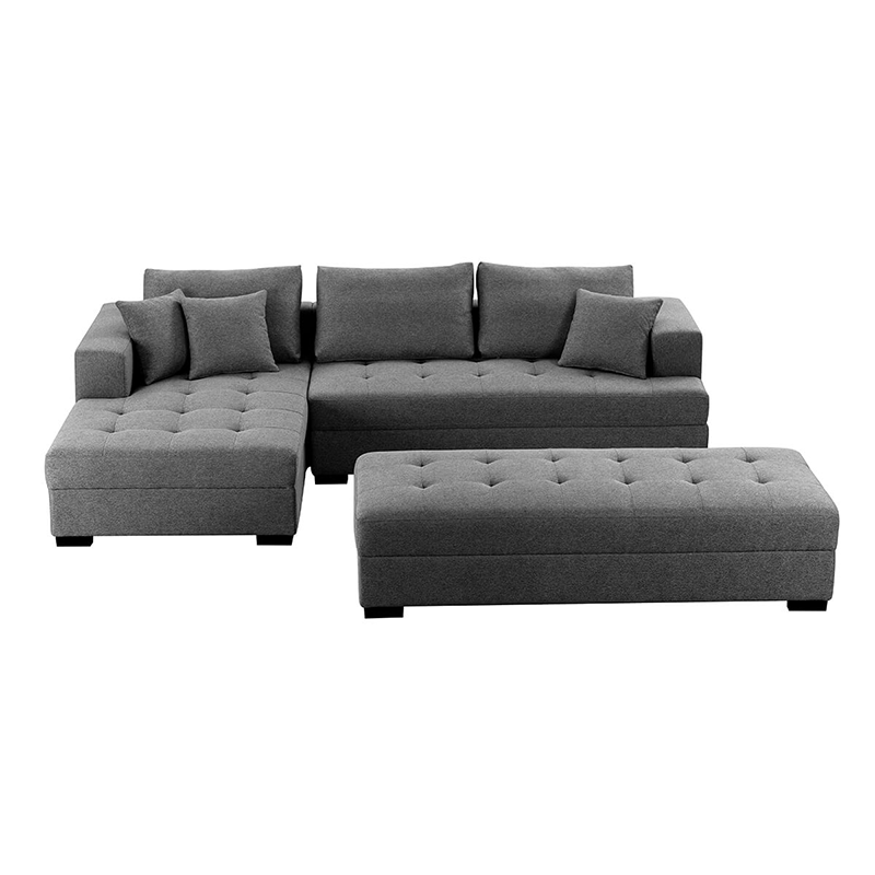 Dark grey tufted sectional sofa with matching ottoman in a contemporary living room.