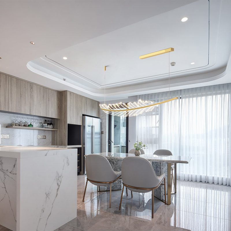 Elegant gold leaf pendant light hanging above a kitchen island, showcasing its unique design.