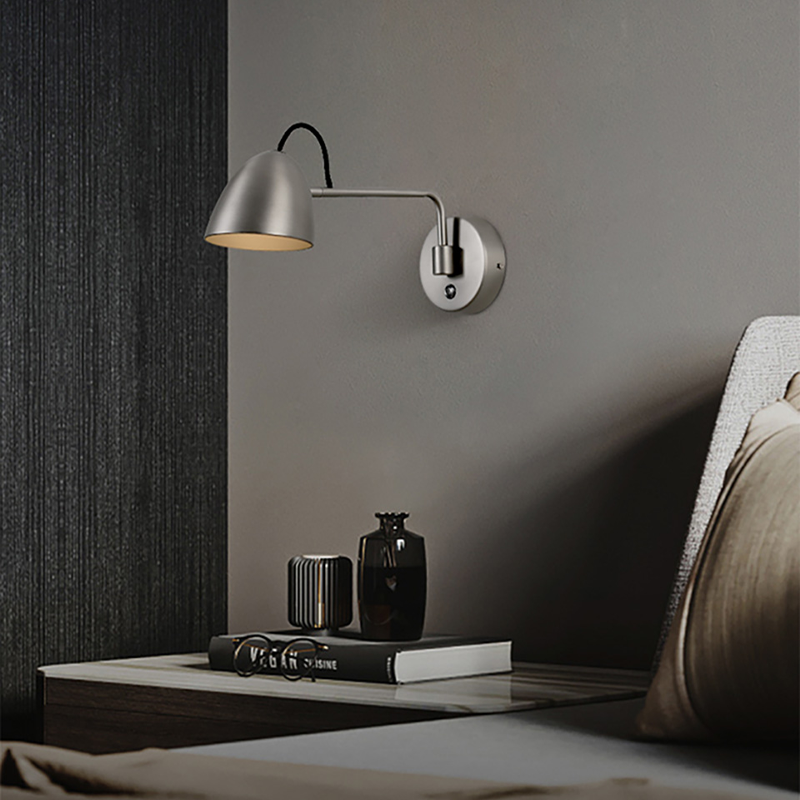 Nickel rocker LED wall light installed above a bedroom headboard — ideal affordable wall light for bedroom.