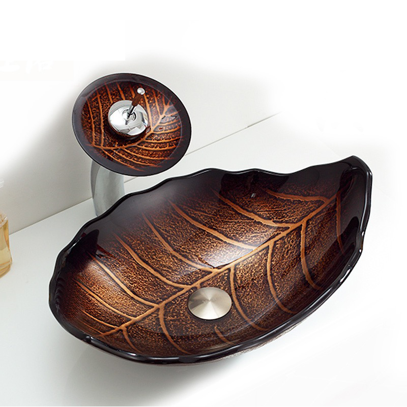 Leaf shaped tempered glass sink with faucet from a side angle, showcasing its artistic design.