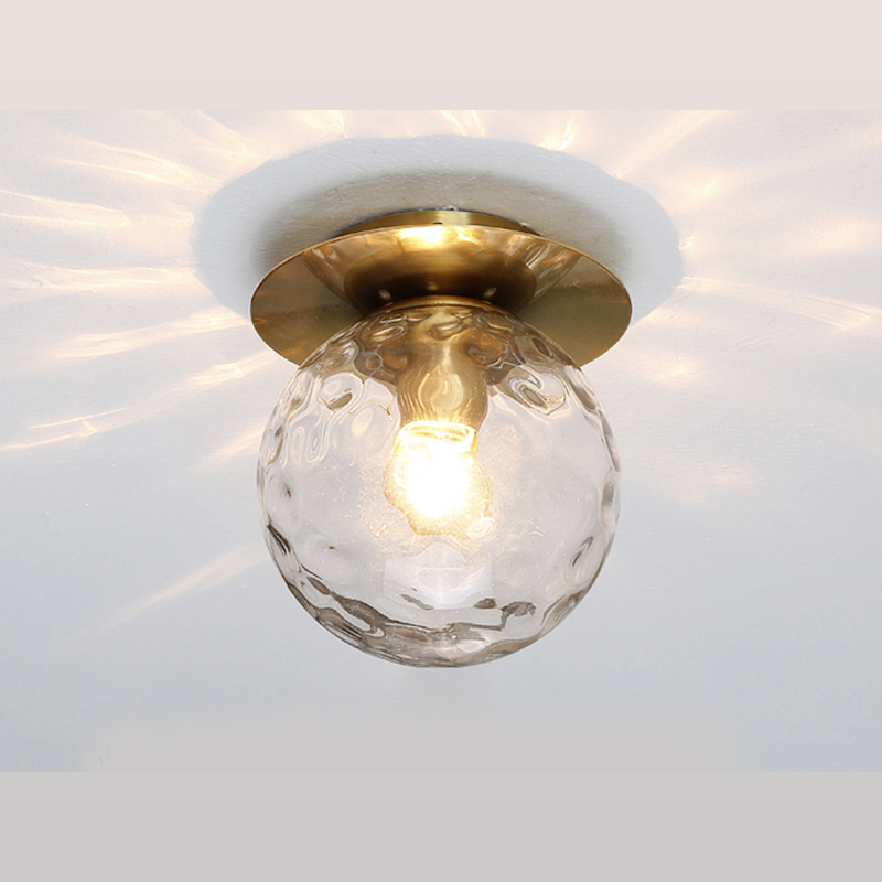Elegant gold flush mount ceiling light showcasing its unique ripple glass design from a side angle.