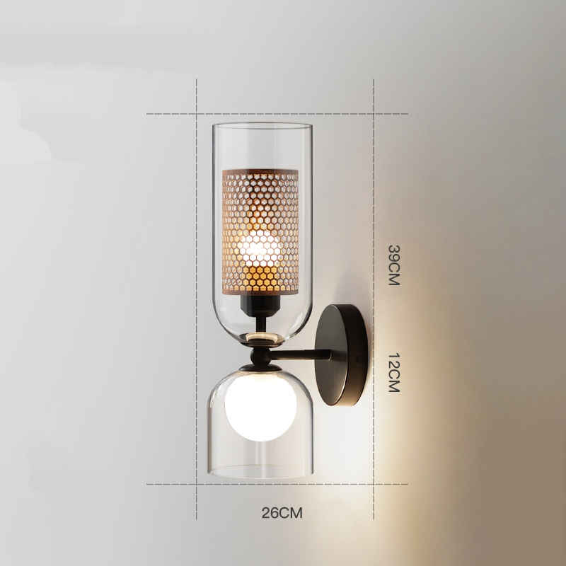 Close-up of stained glass wall sconce glowing downward over console table.