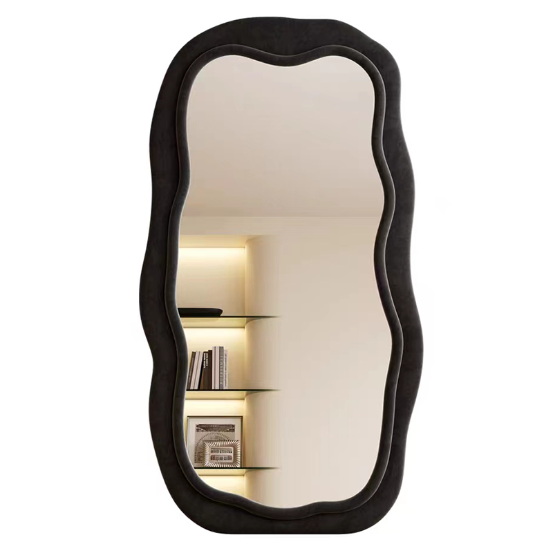 Close-up view of the velvet-wrapped frame of the wavy black mirror reflecting natural light.
