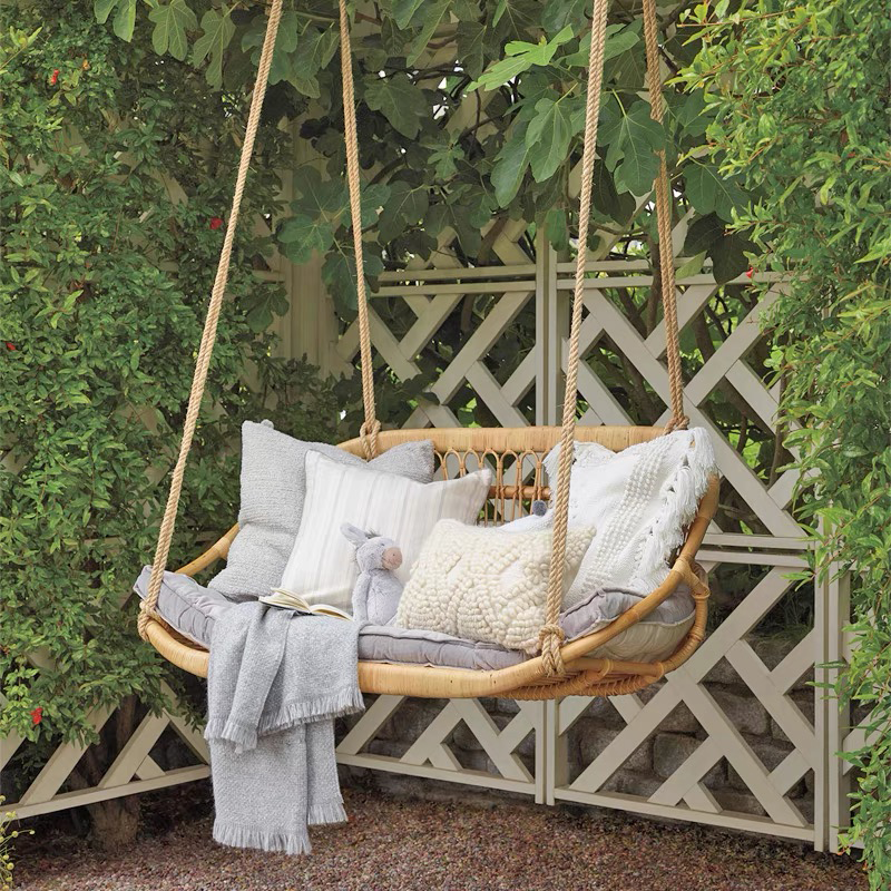 Front view of the handmade swing showcasing rattan texture and curved edges