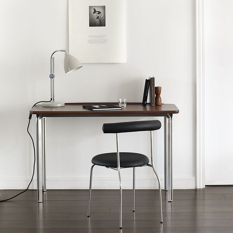 Side angle of the black walnut desk, highlighting the sturdy steel frame and spacious surface.