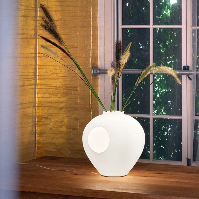 Top-down view of rechargeable vase light illuminating a cozy bedside setup