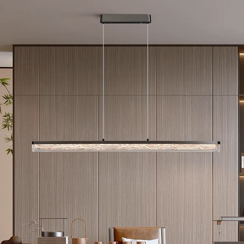 The long strip pendant light illuminating a stylish kitchen island.
