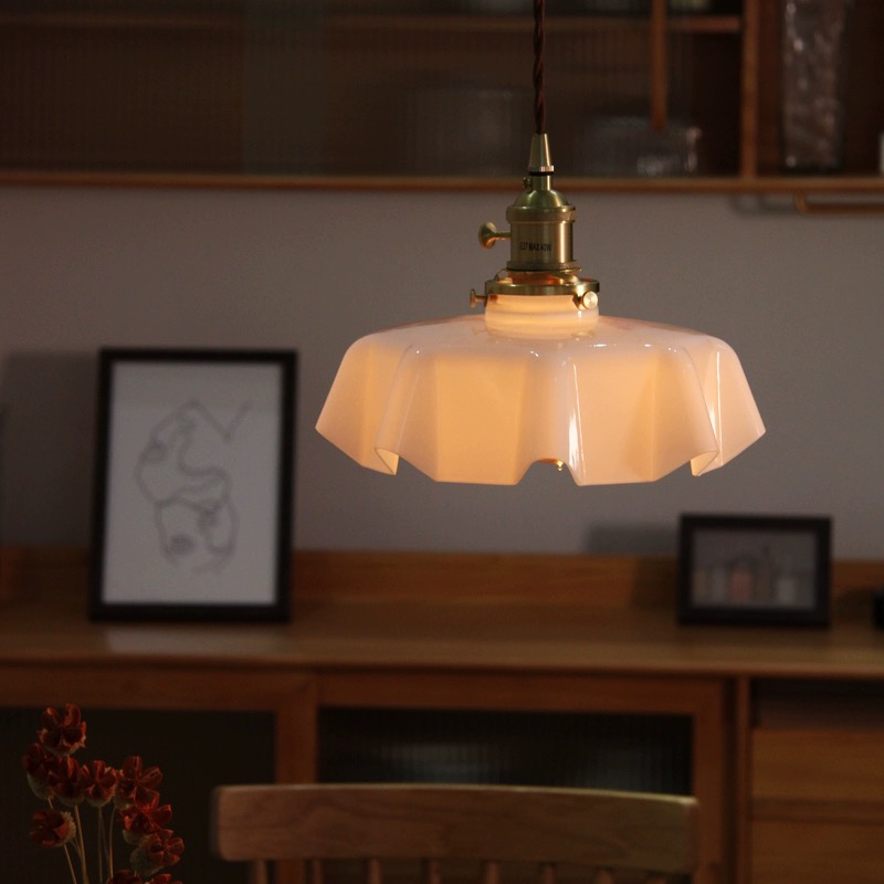 Close-up of the cream-colored glass lampshade highlighting the retro style of the pendant light.