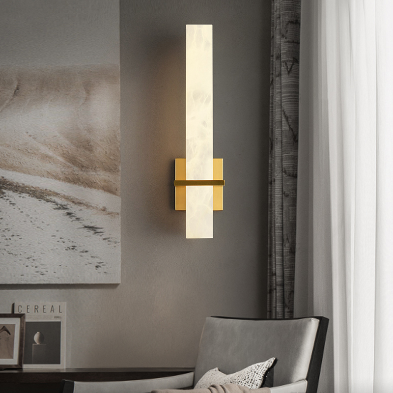 Elegant marble LED wall lamp with golden base, displayed in a stylish bedroom.
