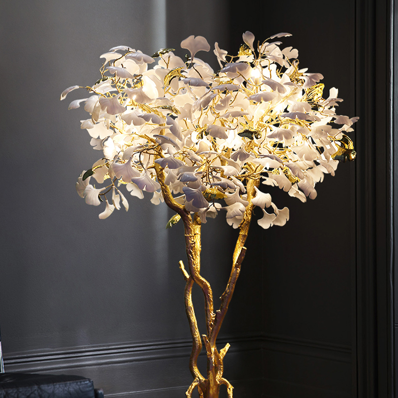 Ginkgo tree floor lamp next to a comfortable reading chair, creating an inviting atmosphere.