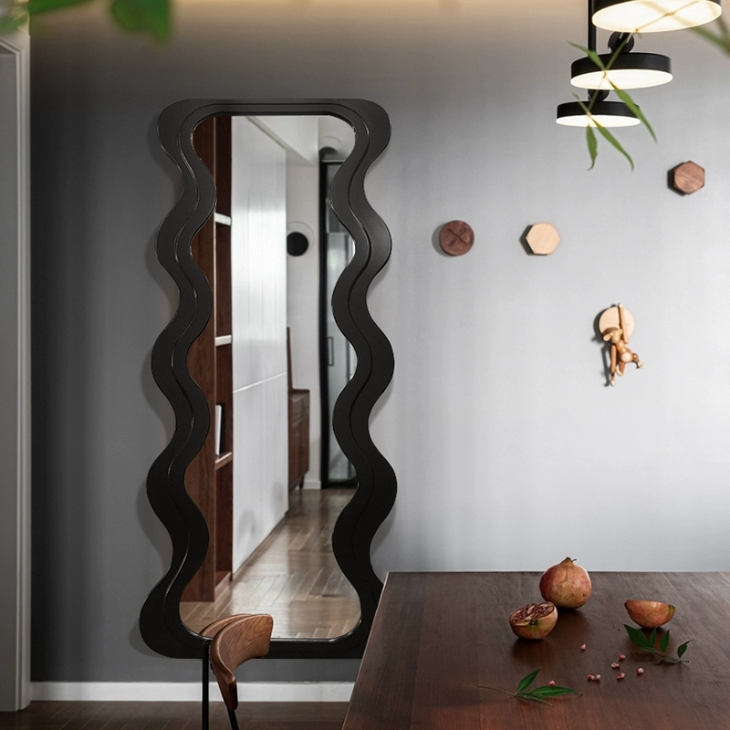 Full length mirror leaning against a wall in a minimalistic living room setting.