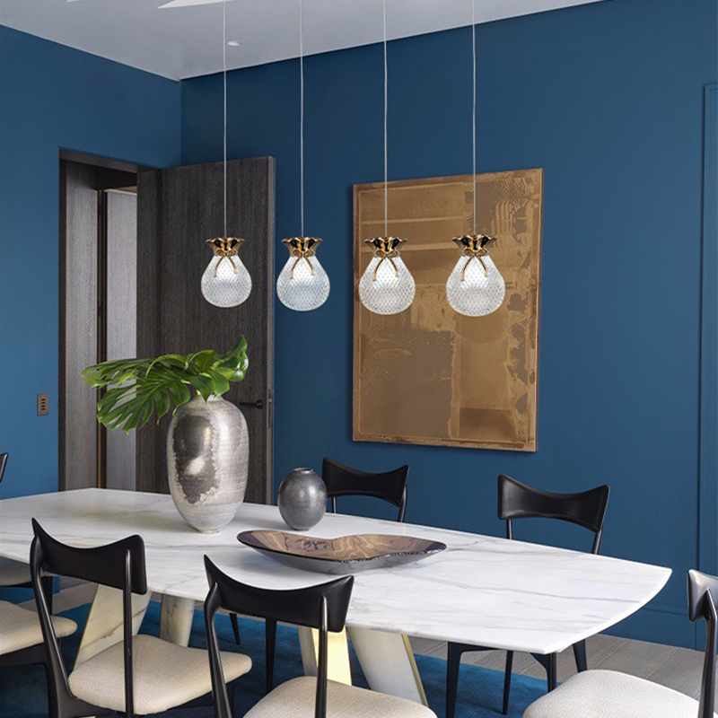 Elegant gold glass pendant light hanging in a modern dining room decor.