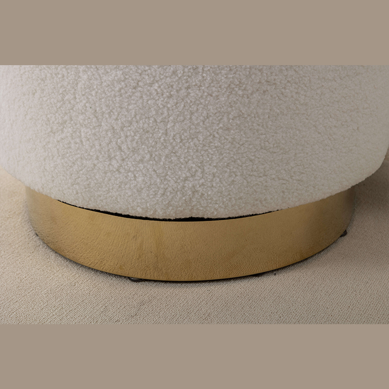 Close-up view of the swivel mechanism on a cream barrel chair with plush upholstery.