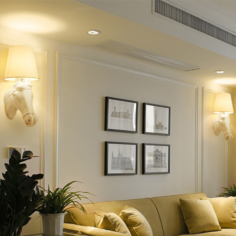 Wall-mounted lamp casting warm light in a modern bedroom interior