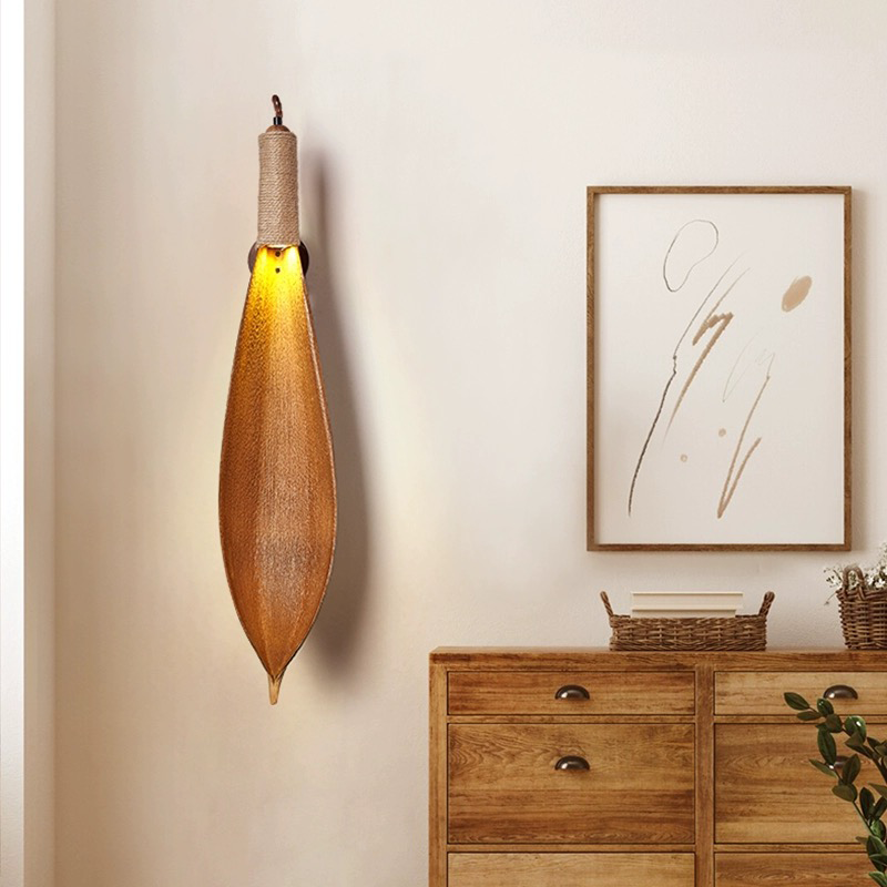 Close-up view of the natural leaf texture and polished finish of the wall lamp.