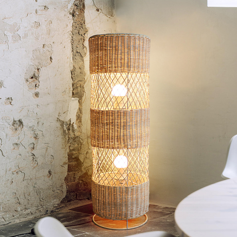 The rattan floor lamp lit up in a cozy living room, emphasizing its warm ambiance and stylish look.