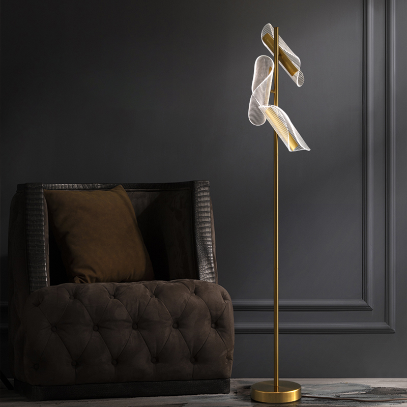 Modern brass stand LED floor lamp in a cozy reading nook, providing ambient light.