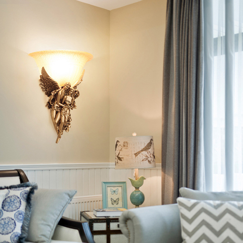 Elegant gold resin angel wall sconce illuminating a stylish living room.