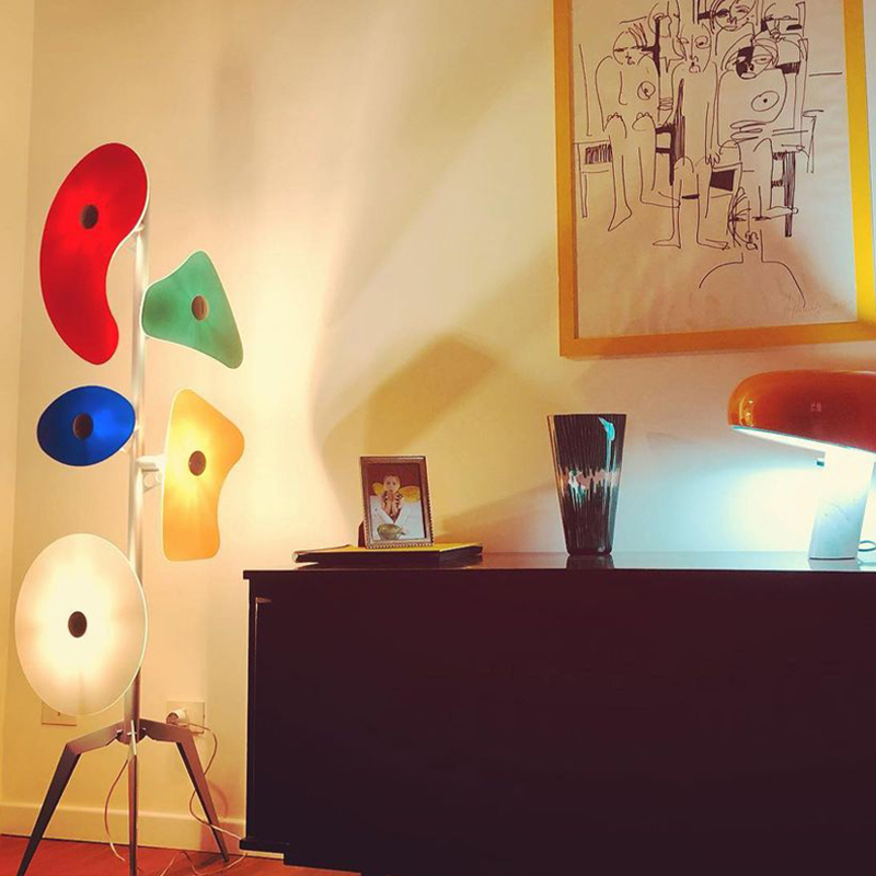 The Elegant Orbital Floor Lamp illuminating a cozy reading nook with its soothing light.