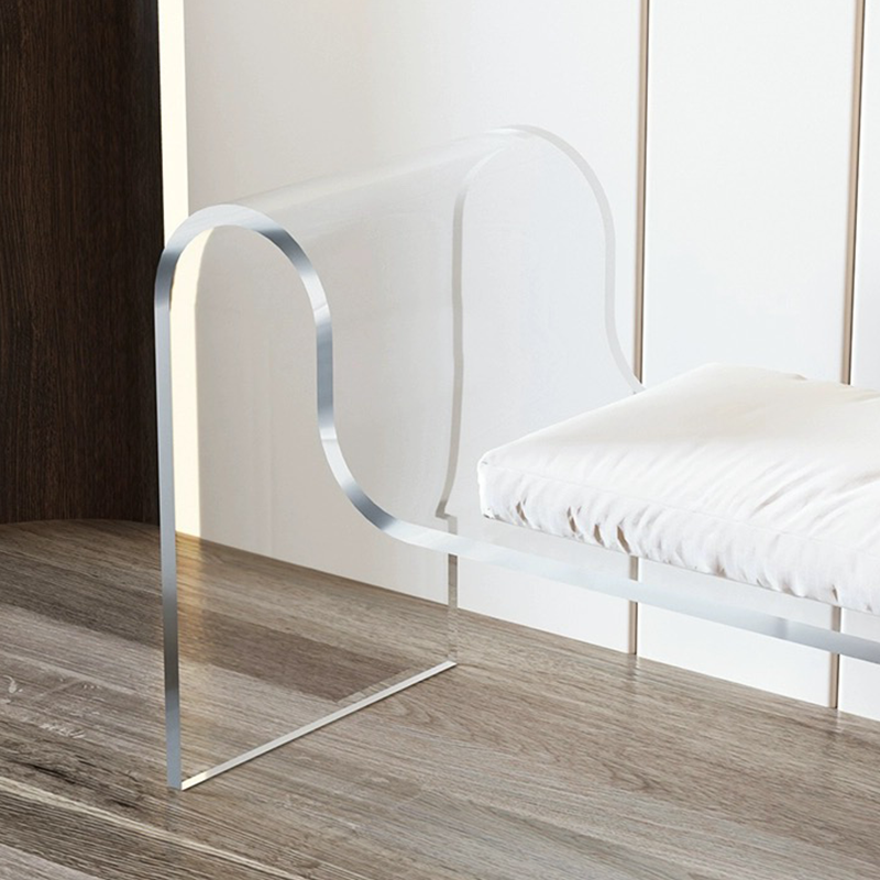 An orange acrylic bench positioned in a stylish entryway, adding vibrant decor.