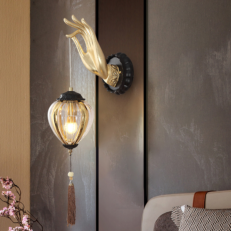 Buddha hand wall lamp displayed in a cozy bedroom setting.
