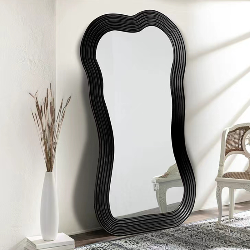 Close-up of the black frame of the floor mirror highlighting its modern design.