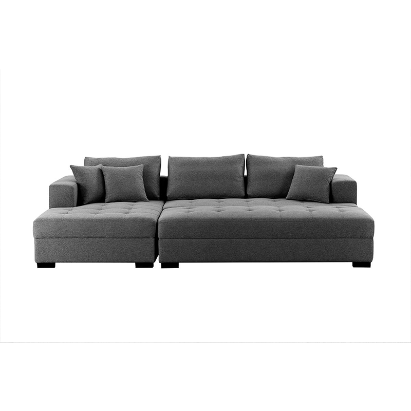 Dark grey tufted sectional sofa with matching ottoman in a contemporary living room.