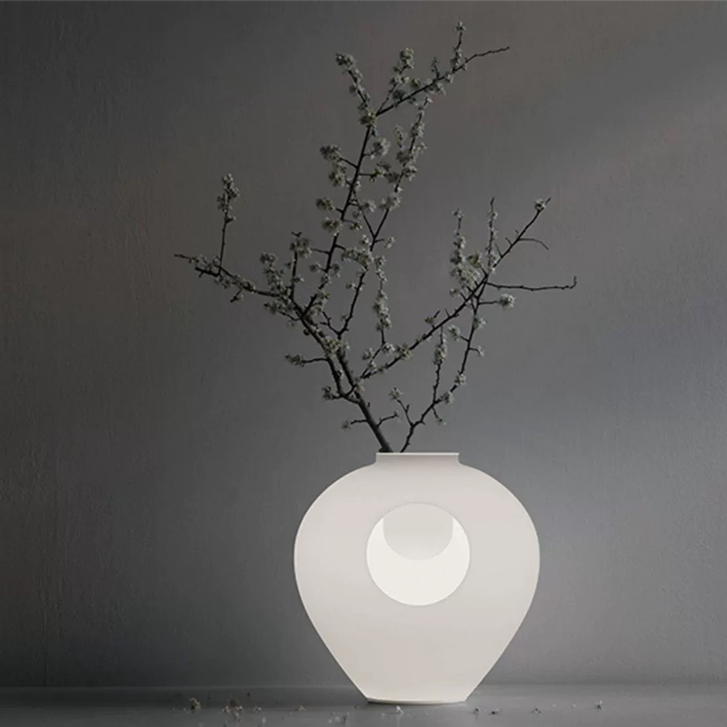 Top-down view of rechargeable vase light illuminating a cozy bedside setup