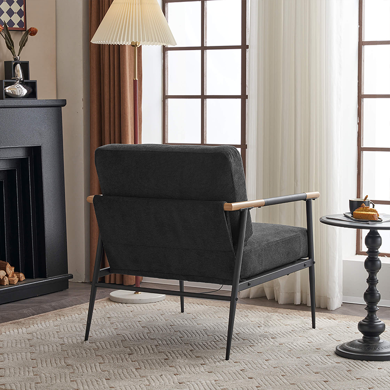 Side view of the sleek black chenille lounge chair with a metal frame in a cozy living room setting.