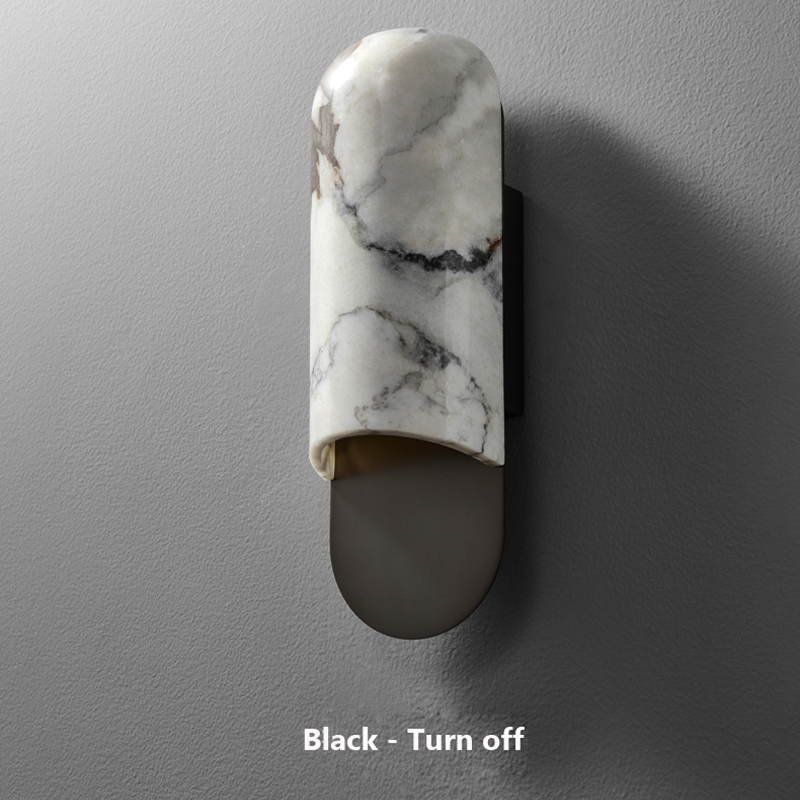 Close-up of the marble texture and copper finish on the wall sconce.