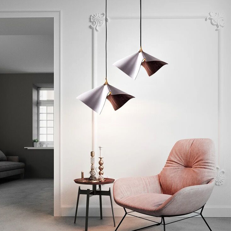 The Nordic wooden pendant light illuminating a modern dining area, enhancing the decor.