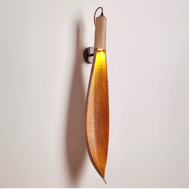 Close-up view of the natural leaf texture and polished finish of the wall lamp.