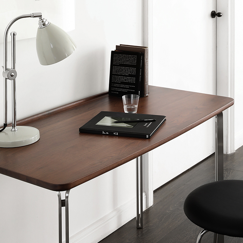Front view of modern black walnut desk with steel legs, showcasing its elegant design.