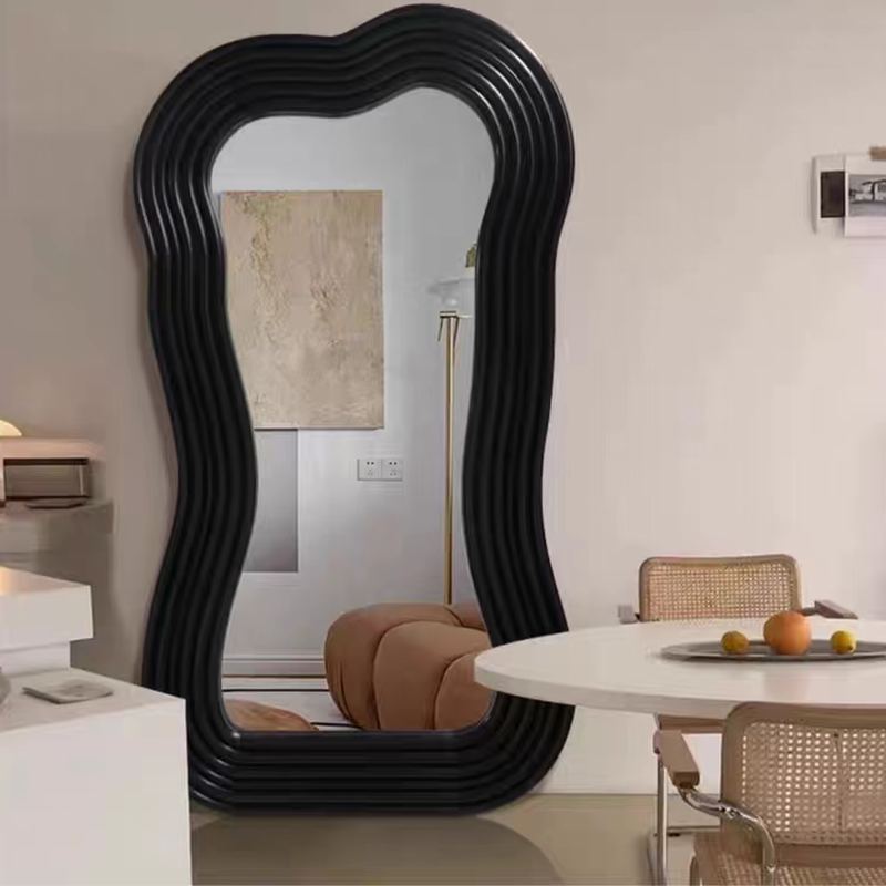 Close-up of the black frame of the floor mirror highlighting its modern design.