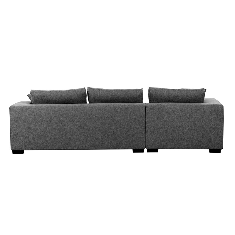 Dark grey tufted sectional sofa with matching ottoman in a contemporary living room.