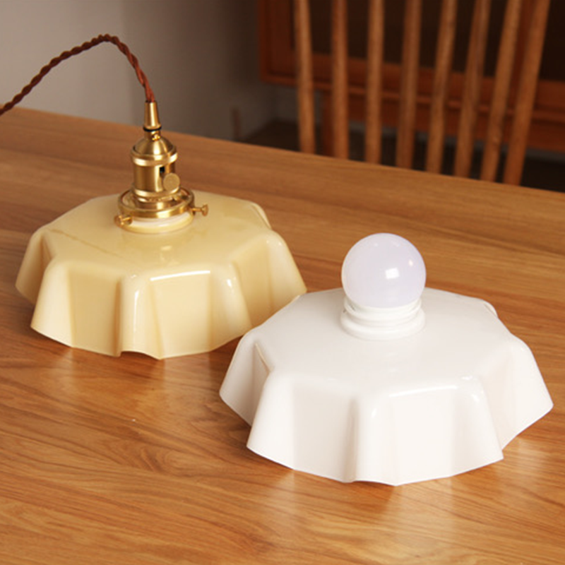 Close-up of the cream-colored glass lampshade highlighting the retro style of the pendant light.