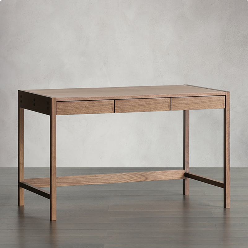 Side angle of the walnut writing desk, highlighting the three drawers and clean lines.