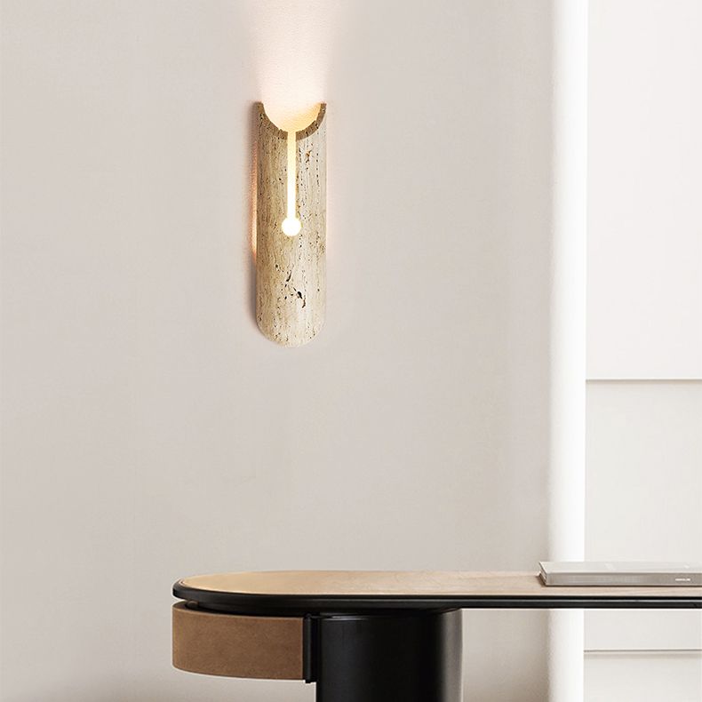 Beige stone shade wall sconce mounted in a cozy bedroom setting
