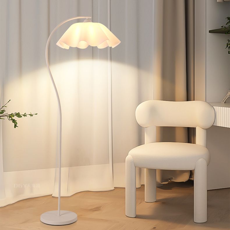 Floor lamp with dome shade illuminating a stylish bedroom corner.
