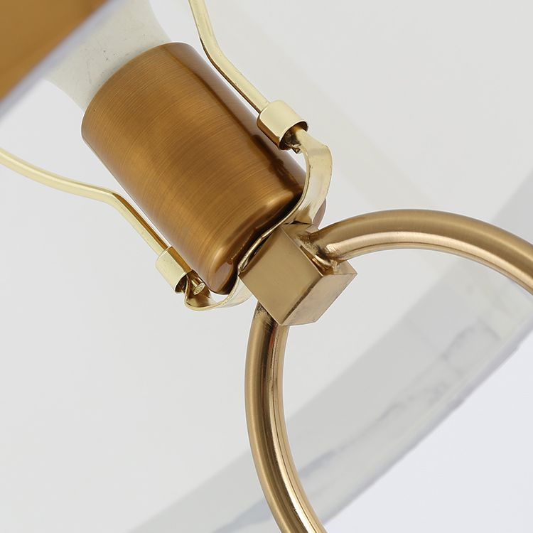 Elegant white column lamp with a drum shade illuminating a stylish living room.