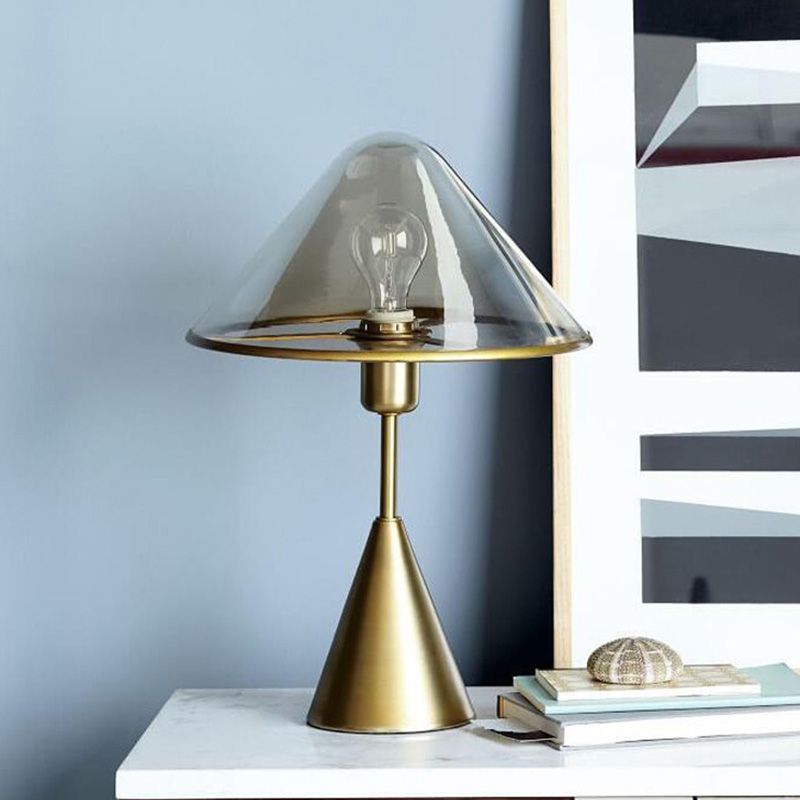 Unique gold table lamp placed on a bedside table, illuminating a warm, inviting ambiance.