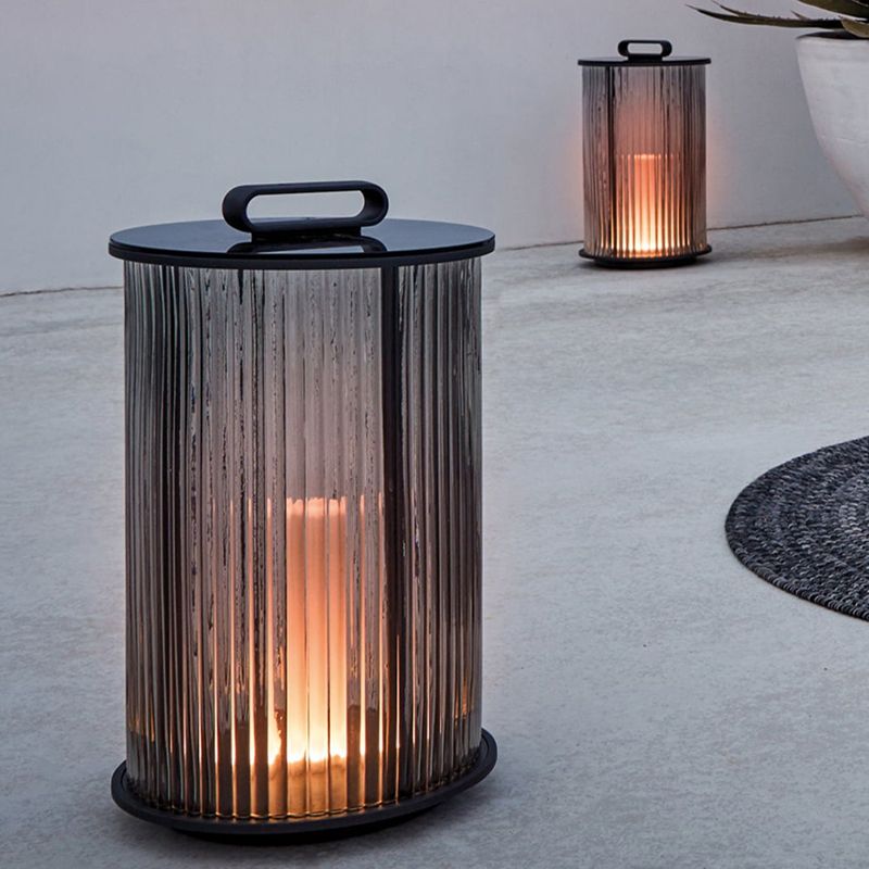 LumiAura metal outdoor lantern placed on garden wall at dusk