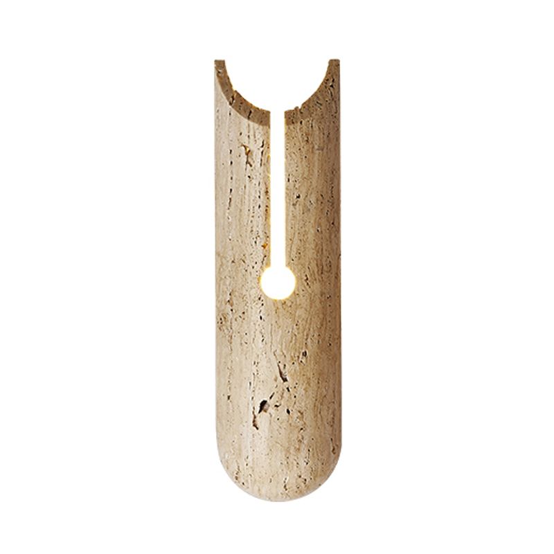 Beige stone shade wall sconce mounted in a cozy bedroom setting