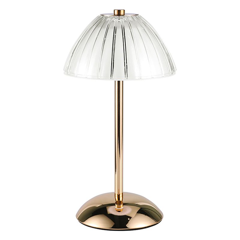 Elegant gold cordless table lamp with glass shade in a cozy living room setting.